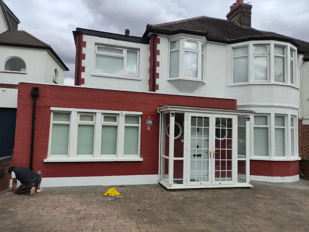 Semi-detached house repainted in red and white masonry paint
