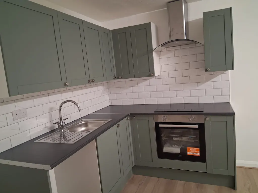 Kitchen with painted sage green shaker cabinets and white subway tile