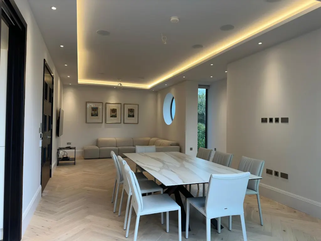 Open-plan dining room with neutral painted walls and ambient lighting